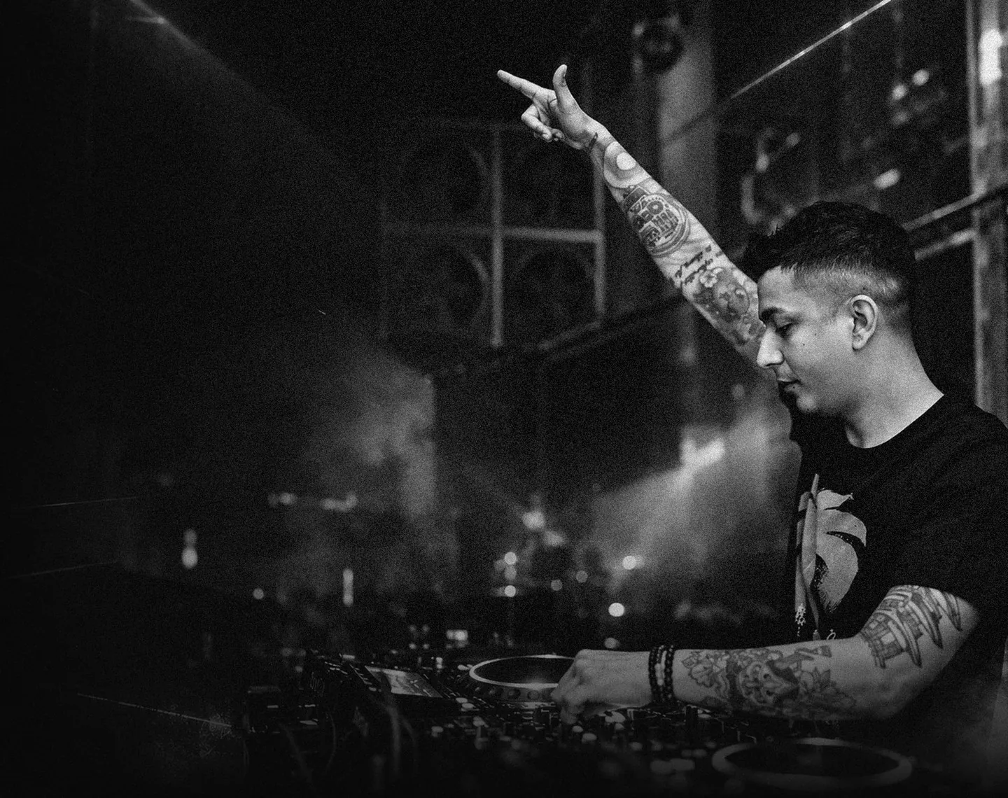 Black and white photo of Scott Jordan with his arm raised at the decks
